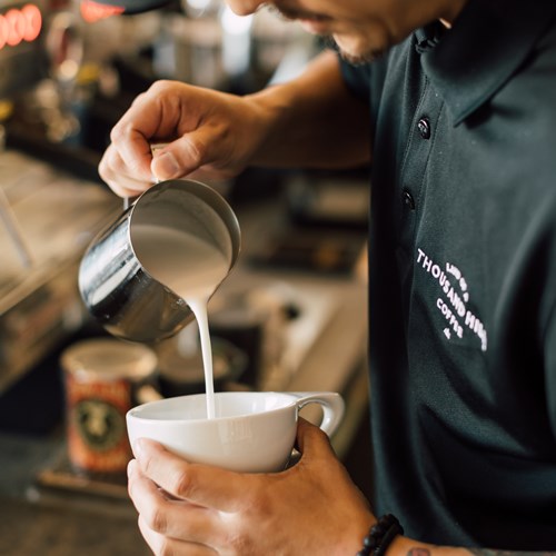 barista pouring a latte at the onsite coffee shop