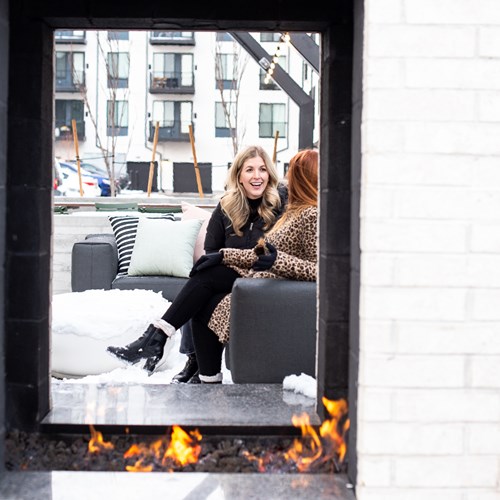 view of two women through an outdoor fireplace