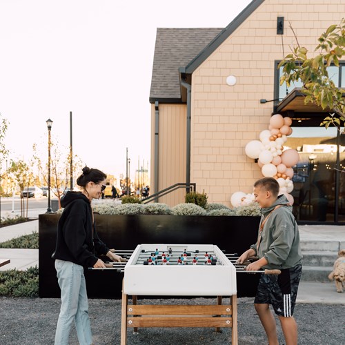 woman and boy playing foosball in the game lawn