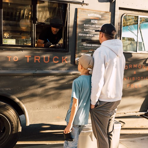 man and boy ordering food at a food truck