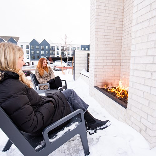 two ladies sitting by the outdoor fireplace