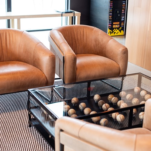 detail shot of the leather chairs and baseball filled coffee table